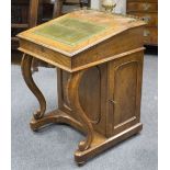 An 19th Century walnut davenport with pierced metal gallery, hinged top with tooled leather inset,