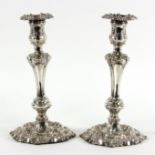 A pair of silver plated candlesticks with heavy scroll mouldings on circular bases,