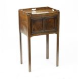 A George III mahogany tray-top pot cupboard, enclosed by a panelled door on chamfered legs,