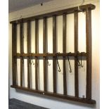 A painted pine hanging game rack with seven horizontal splats and hanging chains for the same,