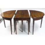 A George III mahogany D-end dining table with dropleaf central section on reeded tapering legs,