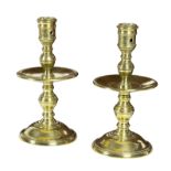 A pair of Heemskerk brass candlesticks, each with a drip tray and circular base,