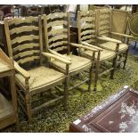 A set of four ladder back chairs with rush seats and open arms