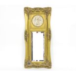 A gilt framed wall mirror with foliate gilt moulding and inset alabaster roundel depicting two