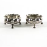 A pair of Chinese export silver salts, of compressed circular form with three scroll legs,