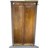 A late 19th Century mahogany corner cupboard enclosed by a pair of doors,