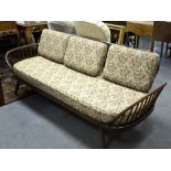 An Ercol settee with panel back and rail supports to the arms, fitted loose cushions, 81.