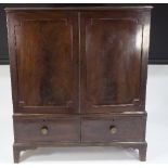 A mid-19th Century mahogany linen press, enclosed by a pair of panel doors above two short drawers,