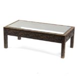 A glass topped coffee table with carved frieze and legs, the top 106.5cm x 55.