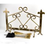 A brass fireguard with scrolling decoration,