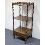 A Victorian rosewood three-tier whatnot with pierced foliate gallery on barley twist supports and