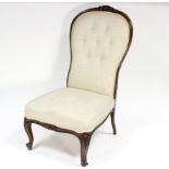 A Victorian carved walnut framed nursing chair and a low wingback armchair