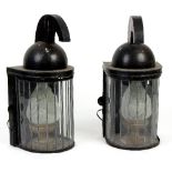 A pair of black painted half-round lanterns with flame opaque shades and helmet type finials,