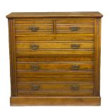 A walnut chest of two short and three long drawers, with swing brass handles,