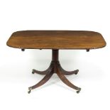 A 19th Century mahogany tilt-top dining table on column supports with four reeded legs,