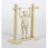 A Chinese carved ivory toy figure of an acrobat, of jointed form on a hanging bar,