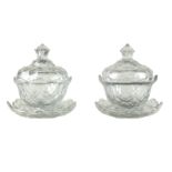 A pair of Irish glass bowls, covers and stands, cut with prisms and stars,