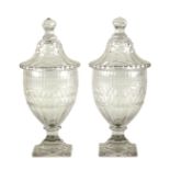 A pair of Irish glass lidded jars, cut with slices and diamonds,