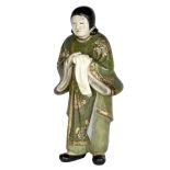 An Oriental lacquered papier-mâché figure of a servant, standing with hands clasped, 35.