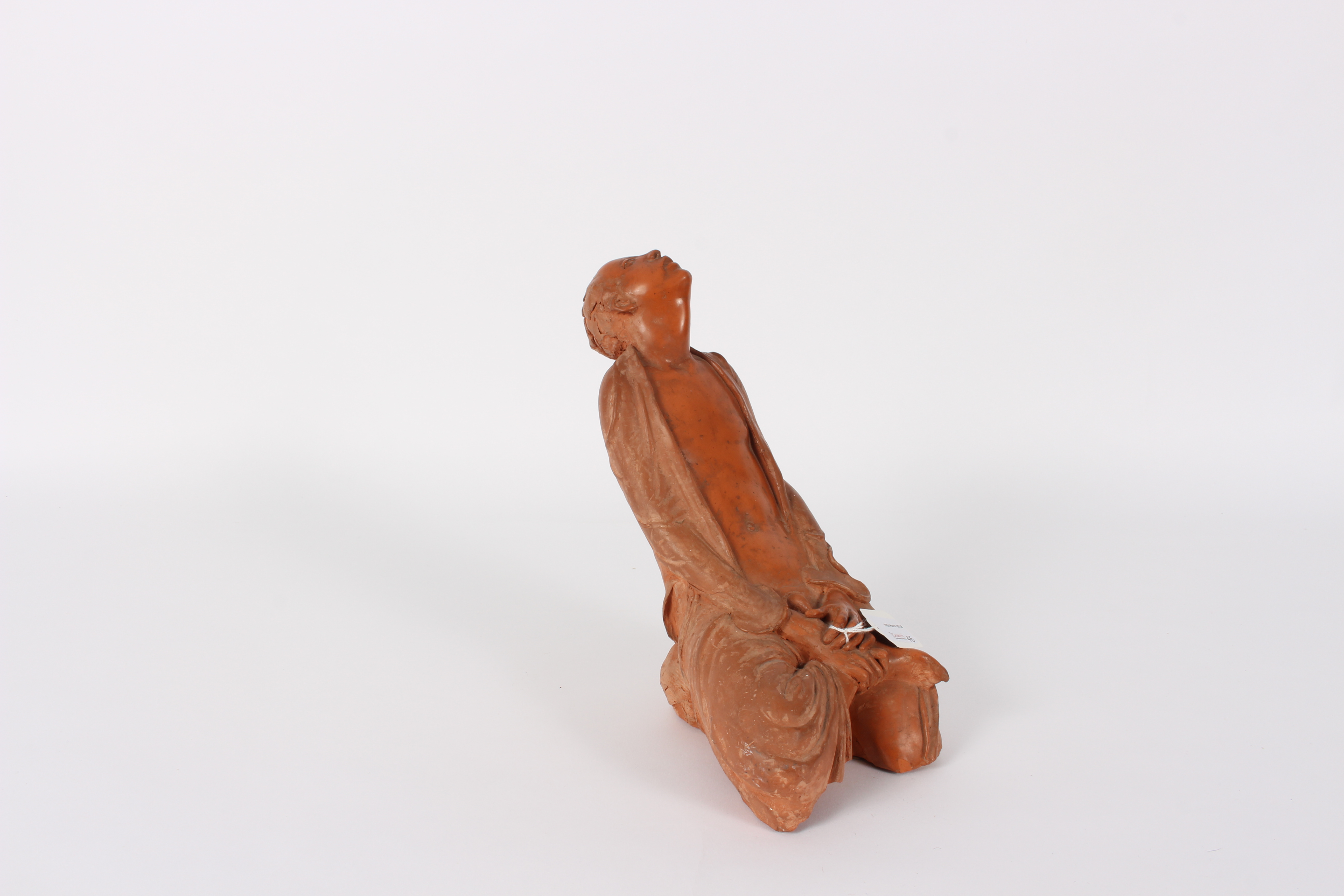 A Japanese pottery figure of a kneeling man, wearing a loose robe, 26.