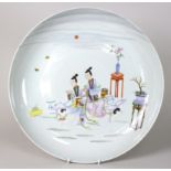 A Chinese famille rose saucer shaped dish, the centre enamelled with Oriental figures, plant stands,