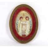 An embroidered oval panel of two angels and a vision of The Host, circa 1900,