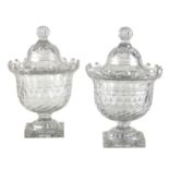 A pair of Irish lidded bowls with diamond cuts, raised on square pedestal bases,