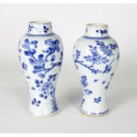 A pair of Chinese blue and white vases, 18th Century, of baluster form decorated flowering branches,