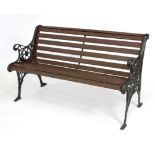 A garden bench with cast iron ends, with pierced rosette decoration,