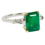 An emerald and diamond dress ring, the central rectangular step cut emerald approximately 2.