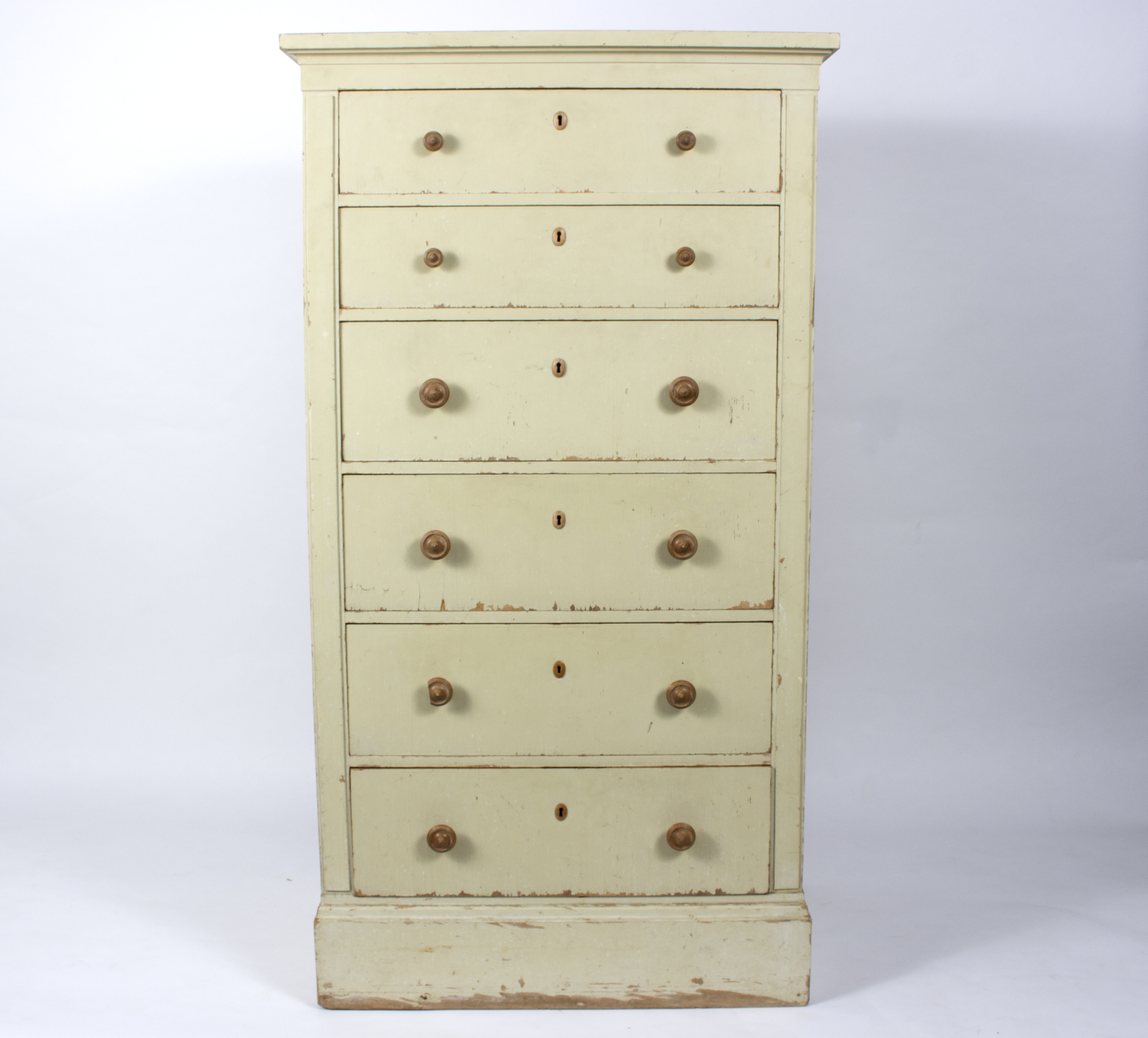 A painted chest of six long drawers, painted in cream,