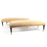 A pair of rectangular footstools with upholstered seats on turned legs,