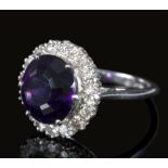 An amethyst and diamond cluster ring, the round mixed cut amethyst measuring approximately 10.