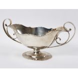 A silver twin-handled vase, London 1906, of oval form with wavy rim and foot, 31.