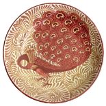 Charles Passenger for William de Morgan/Ruby and copper lustre dish/decorated a peacock in shades