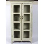 A glazed and painted bookcase, the two doors each with four glazed panels,
