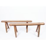 A pair of country made benches on trestle supports,