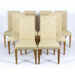 Eight dining chairs upholstered in buttermilk damask with padded seats and backs on square taper