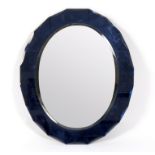 A modern oval wall mirror, the bevelled plate within a blue mirrored border with canted edge,