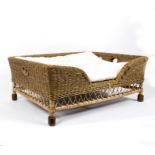 A large wicker dog's bed, possibly OKA,