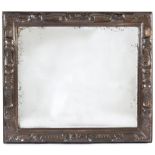 An Art Nouveau beaten and embossed framed wall mirror decorated flowerheads, scrolls and shells,