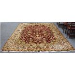 An Eastern style carpet with central red ground field of interwoven flowers,