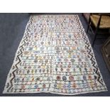 A Navajo style rug, with bands of geometric motifs to a cream ground,