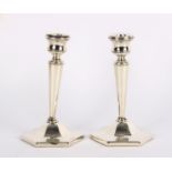 A pair of silver candlesticks, T & S, Birmingham 1958, of tapering column form on hexagonal bases,