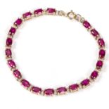 A ruby and diamond line bracelet, the oval stones interspersed by small diamonds, set in 9ct gold,