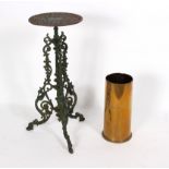 A cast iron plant stand, the circular top on scrolling supports, 77cm high and a brass shell casing,