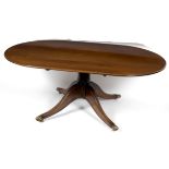 An oval mahogany dining table on a turned column and quadruple support,
