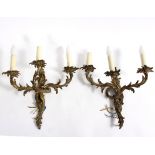 A pair of three-branch gilt metal Rococo style wall lights,