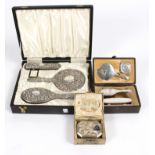 A silver three-piece dressing set with repoussé decoration, in fitted case,