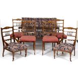 An Edwardian rosewood and inlaid salon suite comprising settee,